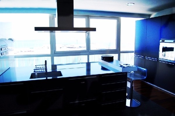 Die moderne Küche mit Kücheninsel und bodentiefen Fenstern