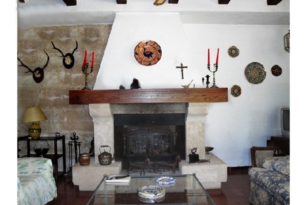Das großzügige Wohnzimmer mit offenem Kamin, dekoriert mit vielen liebevollen Details
