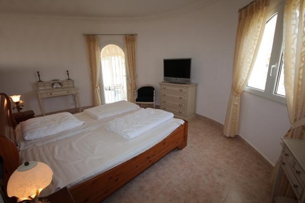 Eines der eleganten Schlafzimmer mit großem Fenster und direktem Zugang zur Terrasse