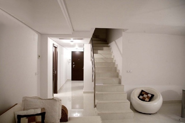 Der exquisite Wohnbereich von dem aus eine Treppe direkt in den zweiten Stock führt