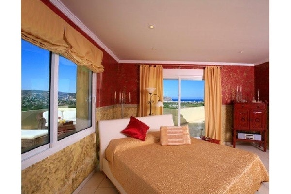Eines der luxuriösen Schlafzimmer mit großer Fensterfront, die einen traumhaften Ausblick garantiert